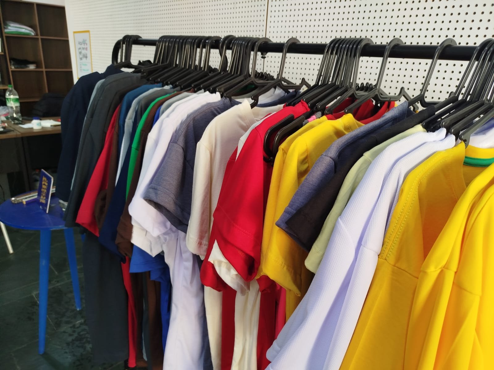 Camisetas e polos alinhados na esteira de produção, prontos para conferência